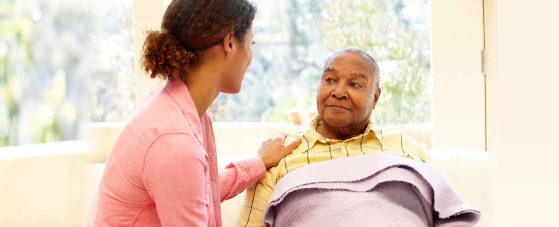 caregiver and elder man looking at each other