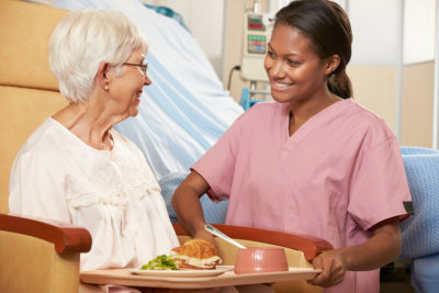 caregiver serving food to her patient