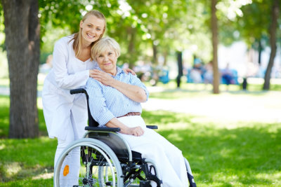 caregiver and senior woman in wheelchair smiling